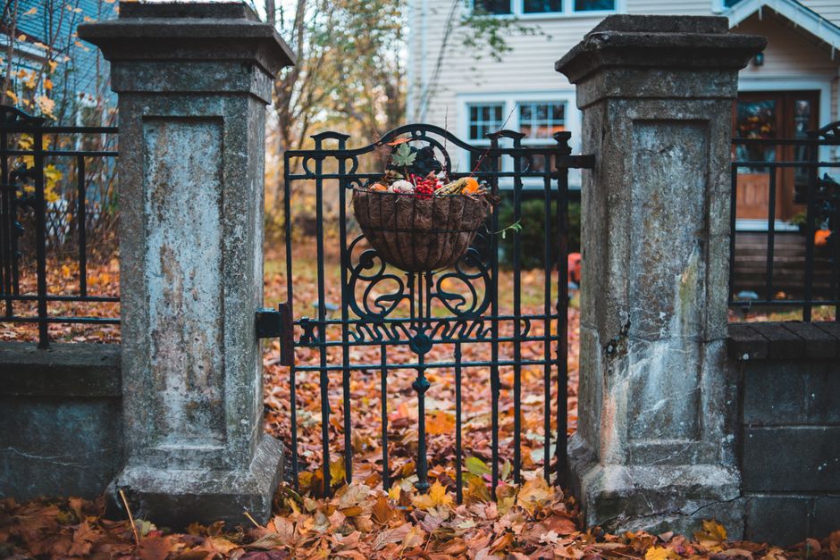 A gate between stone posts leading to a house.