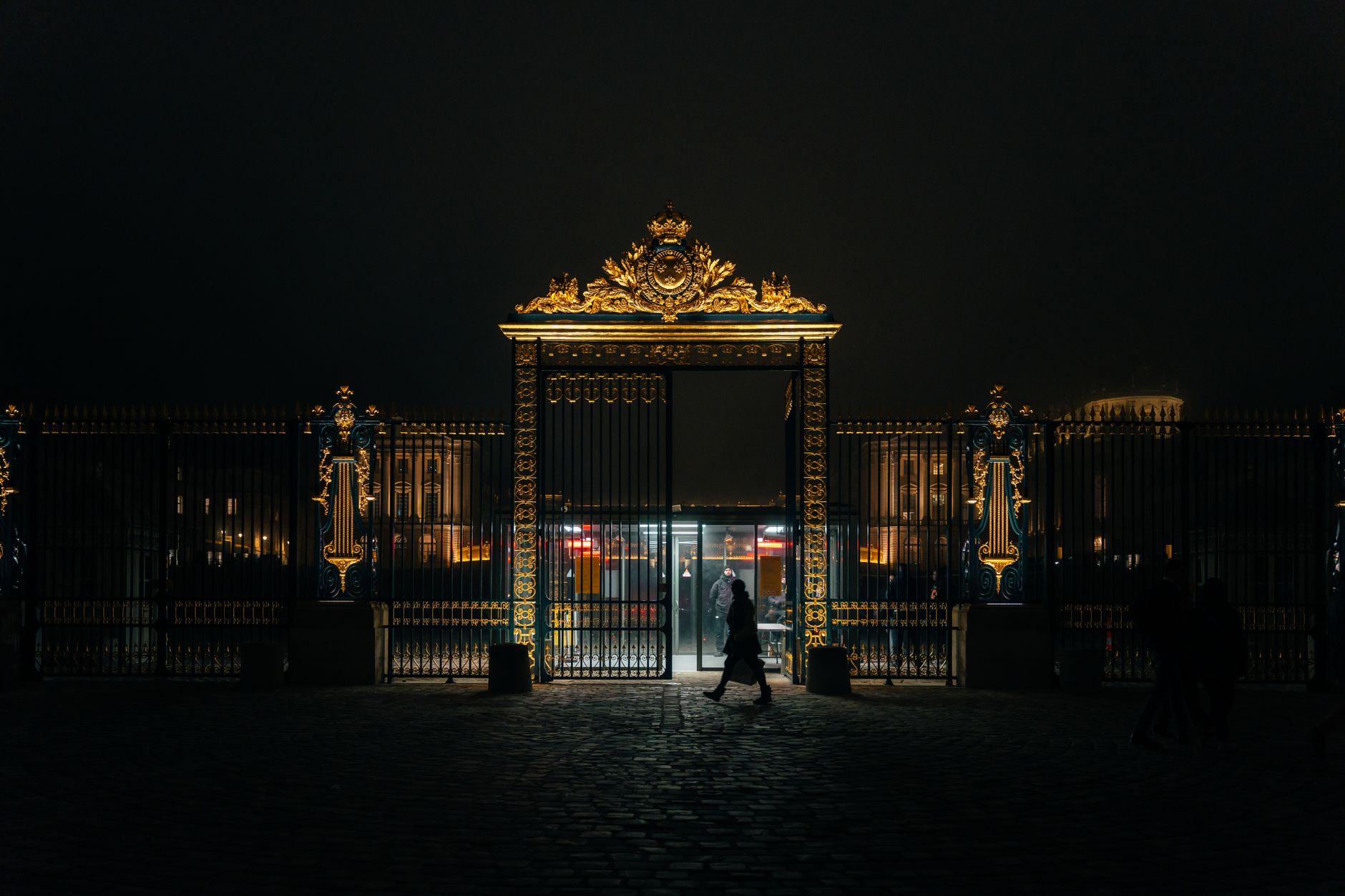 Ornate iron gates lit up at night